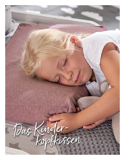 Ein Kind schläft friedlich auf einem rosafarbenen Theraline Kissen in einem gemütlichen Raum. Unten links steht der Text: 