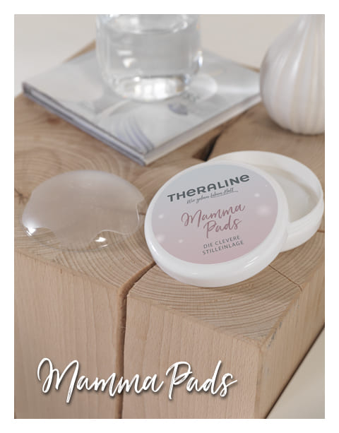 Auf dem Bild sieht man eine kleine, runde weiße Dose, die offen ist.
Auf dem Deckel steht „THERALINE Mamma Pads“ und darunter „Die clevere Stilleinlage“. Neben der Dose liegt ein transparenter, halbmondförmiger Pad, der weich und dünn aussieht. Die Dose steht auf einem hellen Holztisch, daneben sind eine Vase und ein Glas Wasser leicht unscharf im Hintergrund zu sehen.